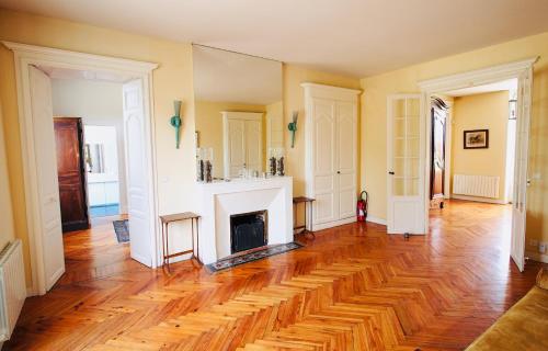 a living room with a fireplace and wooden floors at Domaine de Gorre in Martillac
