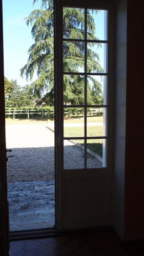 an open door with a view of a field outside at Domaine de Gorre in Martillac