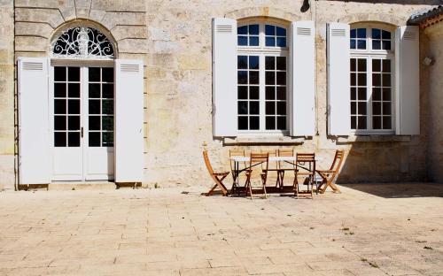 a table and chairs in front of a building at Domaine de Gorre in Martillac