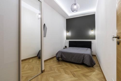 une chambre avec un lit et une porte coulissante en verre dans l'établissement Joli 2 pièces au port de Nice, à Nice