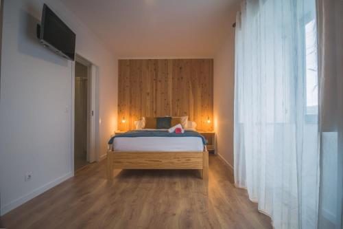a bedroom with a bed and a television in it at Vila Rosario in Ponta Delgada