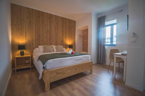 a bedroom with a bed and a table and a desk at Vila Rosario in Ponta Delgada