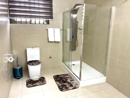 a bathroom with a shower and a toilet at Whispering Hearts Guest House in Bortianor