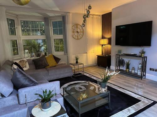 a living room with a couch and a tv at Lush Apartment 2 Bedrooms with Balcony & Parking in Birmingham