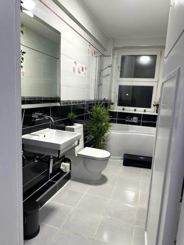 a bathroom with a sink and a toilet and a tub at Lush Apartment 2 Bedrooms with Balcony & Parking in Birmingham