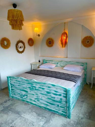 a blue bed in a room with decorations on the wall at Hotel Barba in Urla