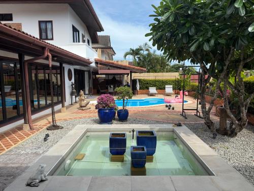 una piscina en el patio trasero de una casa con sillas azules en Very cozy room, en Ban Klang