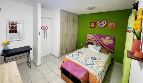 ein Schlafzimmer mit einem Bett und einer grünen Wand in der Unterkunft Casa Comfortable and Complete, maximum 8 people in Tierra Colorada