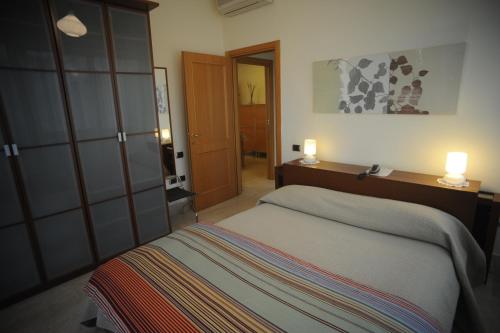 1 dormitorio con 1 cama y 2 luces en la pared en Lux Appartamenti, en Roma