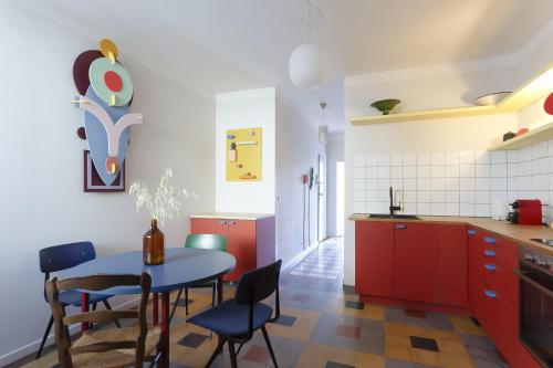 une cuisine avec des armoires rouges et une table et des chaises dans l'établissement Melodie mediterranee - Premiere conciergerie, à Montpellier