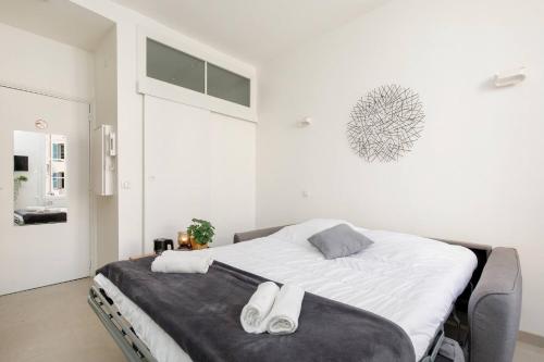 - une chambre blanche avec un grand lit et des draps blancs dans l'établissement Petit bijou de la vieille ville, à Antibes