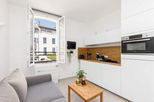 un salon avec un canapé et une cuisine dans l'établissement Petit bijou de la vieille ville, à Antibes