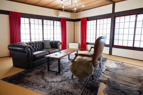 a living room with a couch and a table at 小グループ専門貸切一軒家 パーティーOK観光スポット徒歩圏内 小諸駅歩2分揚羽屋 Specializing in small groups, Party OK, Walking to tourist spots, Vacation Rental House 2 min from Komoro sta in Komoro