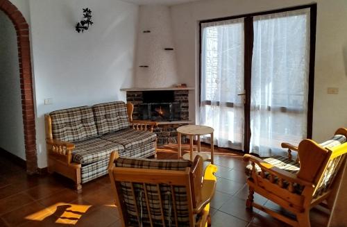 a living room with a couch and chairs and a fireplace at Villa Carla - Bosco in Ledro