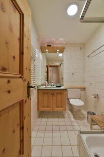 a bathroom with a sink and a toilet and a tub at Chesa Spedlas - Celerina in Celerina