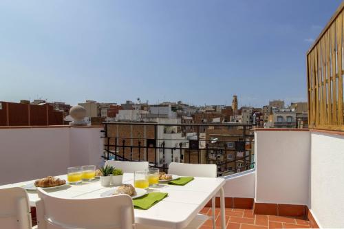 a table on a balcony with a view of a city at Ola Living Camp Nou in Hospitalet de Llobregat