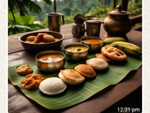 スルタン・バザリーにあるMayoorvihar home stay Sulthaan Bathery Wayanad Keralaの木製のテーブルの皿