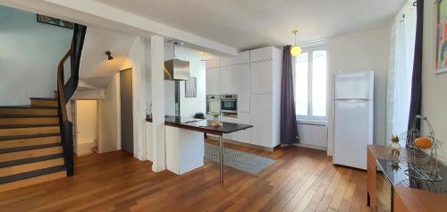 eine Küche mit einem Tisch in der Mitte eines Zimmers in der Unterkunft Maison de Ville Ty Art in Quiberon