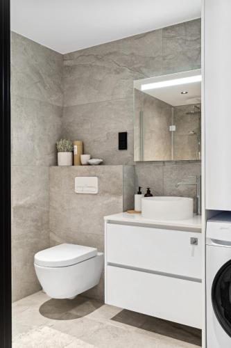 a bathroom with a white toilet and a sink at Lyngvær Tide Lodge - No 13 in Storøya