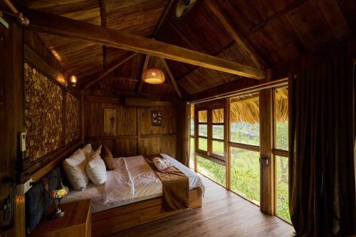 a bedroom with a bed in a wooden room at Mật Retreat in Ba Vì