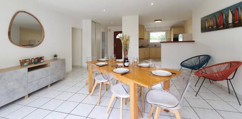 a dining room with a wooden table and chairs at Maison Ty Cloclo in Quiberon