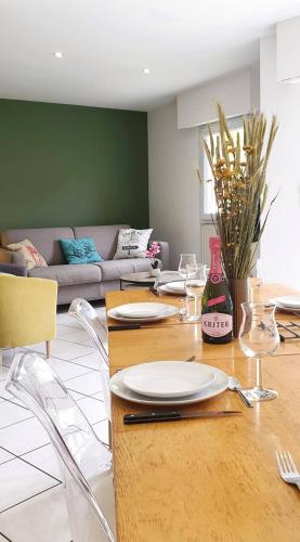 a dining room with a table with plates and wine glasses at Maison Ty Cloclo in Quiberon
