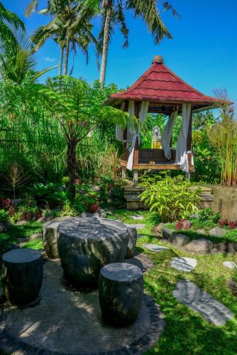 a gazebo in a garden with trees and plants at One Bali Villa in Bangli
