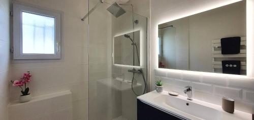 a white bathroom with a shower and a sink at Maison Ty Cloclo in Quiberon