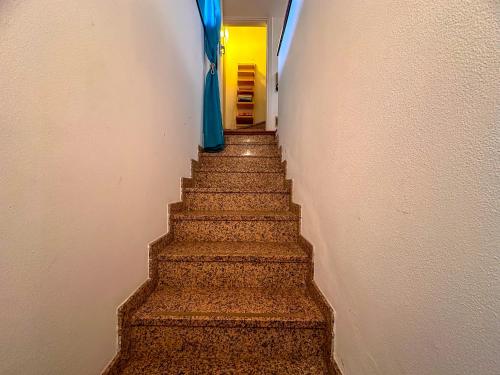 a stairway leading up to a hallway with blue curtains at Appartamento a due passi dal lago con box in Dorio