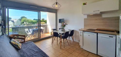 Il comprend une cuisine avec une table et un balcon. dans l'établissement Appartement La Brise Marine, à Quiberon