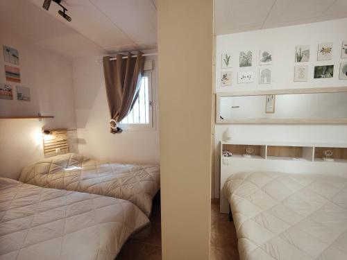 une chambre avec deux lits et une fenêtre dans l'établissement Casa con vistas al mar y a la montaña en la Almadrava AV-36, à Roses