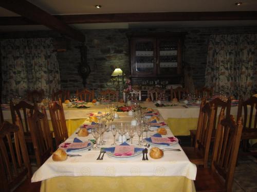 una mesa larga con platos y vasos. en A Lareira, en Chan de Vilar