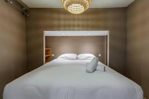 une chambre avec un grand lit blanc avec un lustre dans l'établissement Chic Old Town Apartment, à Nice