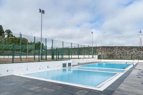 an empty swimming pool in a tennis court at Rooftop Terrace Apartment PDL in Ponta Delgada