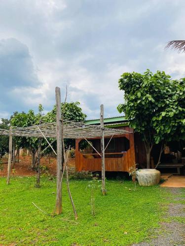 a wooden house with a fence in the grass at Cardamom Community Center in Moăt Preăh