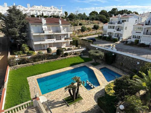 - une vue aérienne sur un bâtiment et une piscine dans l'établissement Apartamento vista piscina AV-28, à Roses