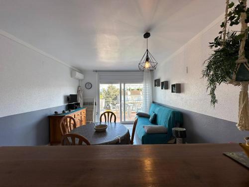 un salon avec une table et un canapé bleu dans l'établissement Apartamento vista piscina AV-28, à Roses