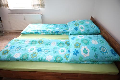 a bed with blue comforter and pillows on it at Bermuda Apartment in Bochum
