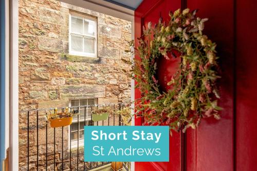 a wreath on a red door with the words short stay st andrews at Little Haven - St Andrews Town Centre in St. Andrews
