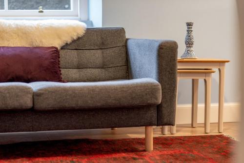 a living room with a couch and a side table at Little Haven - St Andrews Town Centre in St. Andrews