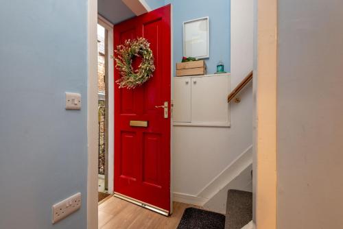 a red door with a wreath on it in a hallway at Little Haven - St Andrews Town Centre in St. Andrews