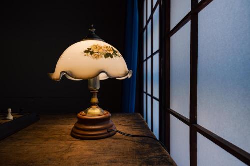 a lamp sitting on a table next to a window at 小グループ専門貸切一軒家 パーティーOK観光スポット徒歩圏内 小諸駅歩2分揚羽屋 Specializing in small groups, Party OK, Walking to tourist spots, Vacation Rental House 2 min from Komoro sta in Komoro
