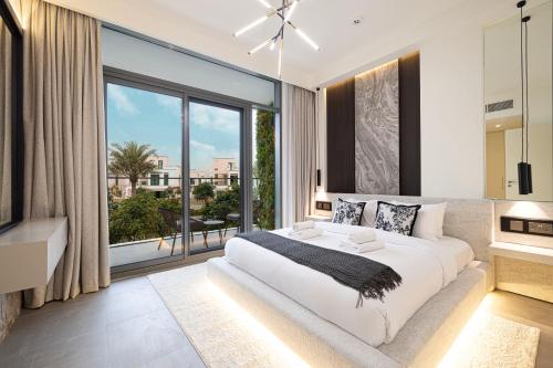 a bedroom with a large bed and a large window at Luxury 4BR Villa, Bali Pool Retreat, Ruba A Ranches 3 in Dubai
