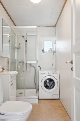 a bathroom with a washing machine and a toilet at Valen House, Reine in Reine