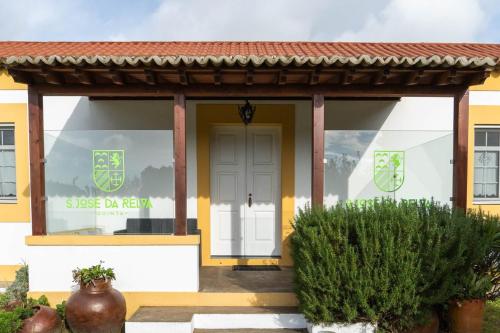 a yellow and white house with a white door at Quinta São José da Relva in Ponta Delgada