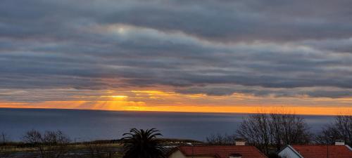 a sunset over the water with the sun in the sky at Quinta São José da Relva in Ponta Delgada