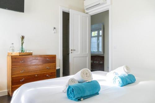 a bedroom with two white beds and a dresser at Quinta São José da Relva in Ponta Delgada