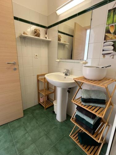 une salle de bain avec un lavabo et un miroir dans l'établissement T3 climatisé pour 4 à 6 personnes proche mer en Corse, à Linguizzetta