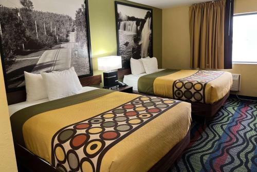a hotel room with two beds and a picture on the wall at Super 8 by Wyndham Farmington in Farmington