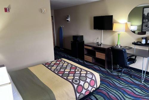 a hotel room with a bed and a desk at Super 8 by Wyndham Farmington in Farmington